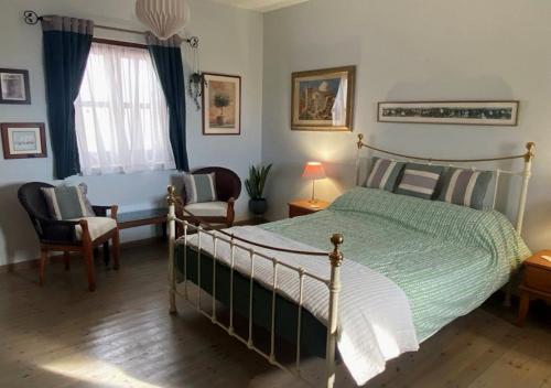 a bedroom with a bed and a chair and a window at Olive Tree House in Anoyira
