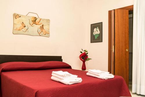 a bedroom with a red bed with towels on it at La Casa Di Rosa in Matera