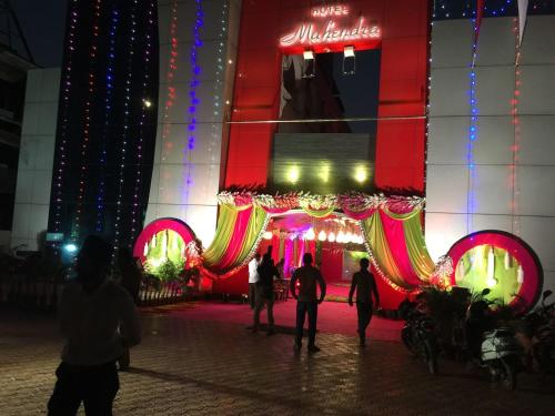 people standing in front of a building with christmas lights at Hotel Mahendra in Jālgaon