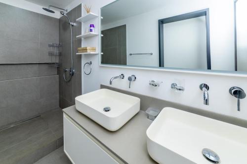 a white bathroom with a sink and a mirror at OBiches Penthouse C1 Beachfront Complex in Trou aux Biches