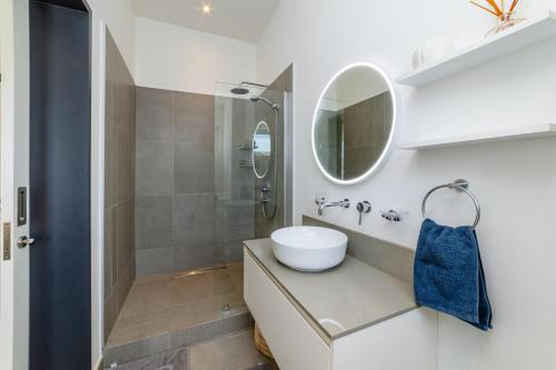 a white bathroom with a sink and a mirror at OBiches Penthouse C1 Beachfront Complex in Trou aux Biches