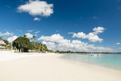 a white beach with boats in the water at OBiches Penthouse C1 Beachfront Complex in Trou aux Biches
