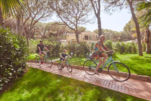 a group of people riding bikes down a path at Forte Village Resort - Il Castello in Santa Margherita di Pula