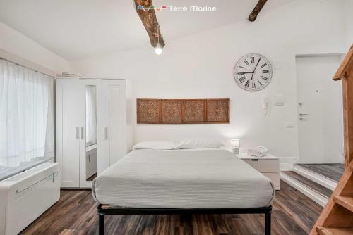 a bedroom with a bed and a clock on the wall at Maestrale 11, Terre Marine in La Spezia