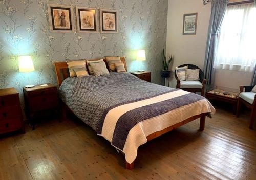 a bedroom with a bed and two tables and two lamps at Olive Tree House in Anoyira