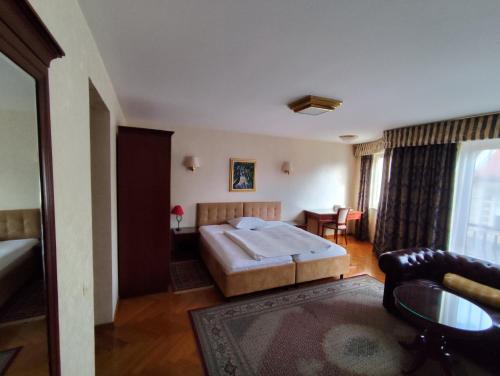 a hotel room with a bed and a table at Hotel Vila Ariston in Osijek