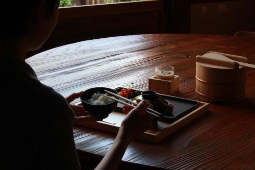 a person sitting at a table with a plate of food at 酒蔵宿西山 鼓傳 -koden- in Tamba