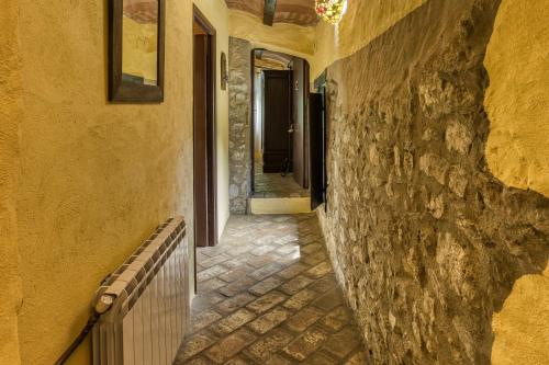 an alley with a stone wall and a hallway at Can Pei in Oix