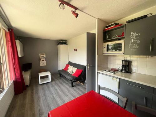 un petit salon avec un canapé et une cuisine dans l'établissement Résidence Alpina 3 - Agréable appartement T3 secteur calme pied des pistes MAE-5481, à Vénosc