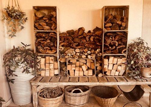 a wall filled with lots of different types of logs at Olive Tree House in Anoyira