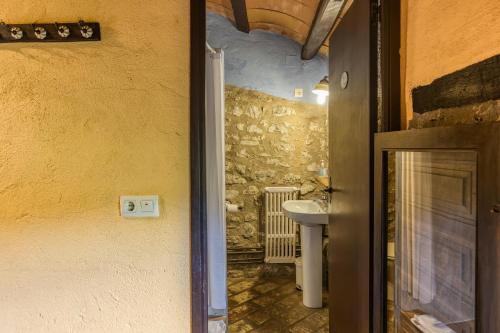 a door leading to a bathroom with a sink at Can Pei in Oix