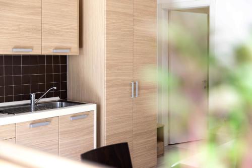 a kitchen with a sink and wooden cabinets at Villaggio San Paolo in Cavallino-Treporti