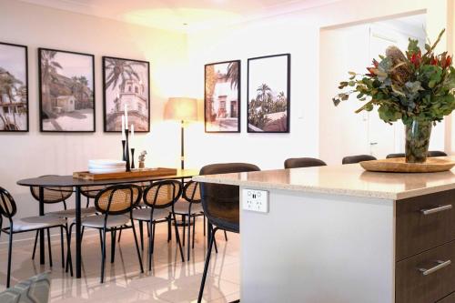 a kitchen and dining room with a table and chairs at Waterfront Stay at Sunshine Villa in Maroochydore