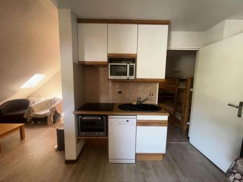 une petite cuisine avec un évier et un micro-ondes dans l'établissement Résidence Apheratz-porte F57 - Ravissant appartement 6 personnes sur les hauteurs de la station-Parking privé MAE-5731, à Vénosc