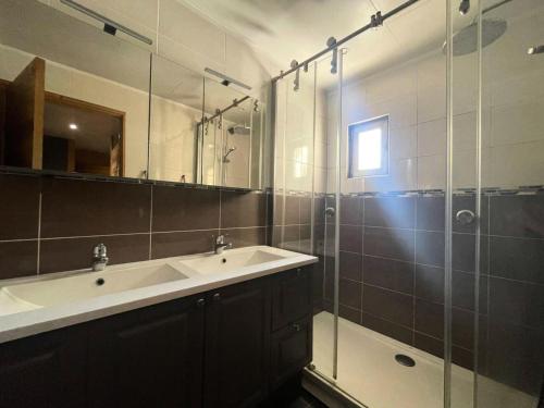 une salle de bain avec un lavabo et une douche en verre dans l'établissement Résidence Les Bleuets - Appartement Coup de coeur en Plein Centre de station avec cave privative MAE-5391, à Vénosc