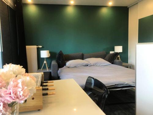 a bedroom with a bed and a green wall at Résidence Midi - Les Deux Alpes – Appartement tout confort avec balcon plein sud et vue sur la Muzelle MAE-5511 in Les Deux Alpes