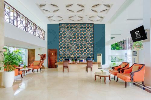a lobby with chairs and a table in a building at 1O1 URBAN Heritage Yogyakarta Lynn Prawirotaman in Yogyakarta