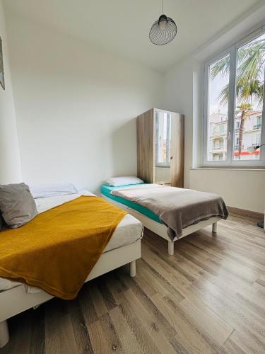 une chambre avec deux lits et une fenêtre dans l'établissement T3 City Center MENTON, à Menton
