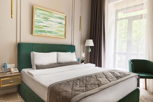 a bedroom with a large bed and a window at Maestro Address Baku Hotel in Baku
