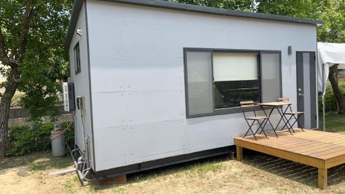 Starveil Mountain Retreat X by Tiny Away : منزل صغير أبيض مع شرفة ومقاعد