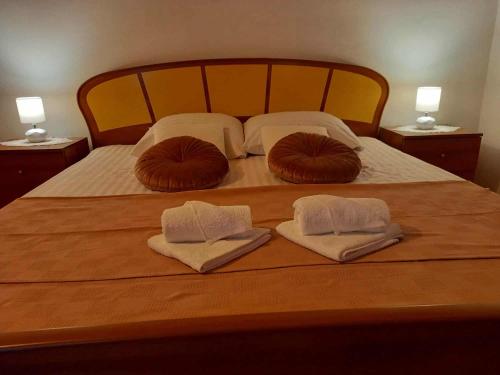 a bed with two pillows and two towels on it at Petra in Ražanac