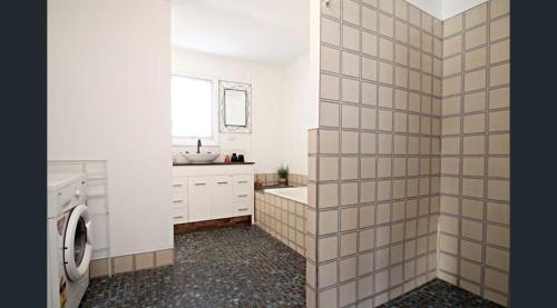 a bathroom with a sink and a toilet and a tub at LMN Cottage in Spalding