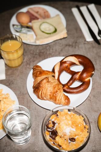a table with plates of bread and pastries on them at FortyPlusOne Hotel Vienna in Vienna
