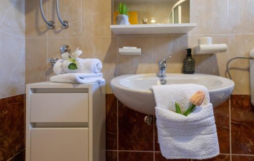 a bathroom with a sink and towels on a counter at Country house Maslina by Villas Guide in Metković