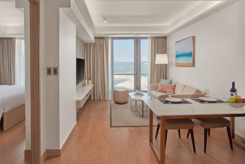 a hotel room with a bed and a dining room at Lanson Place Mall of Asia Manila in Manila