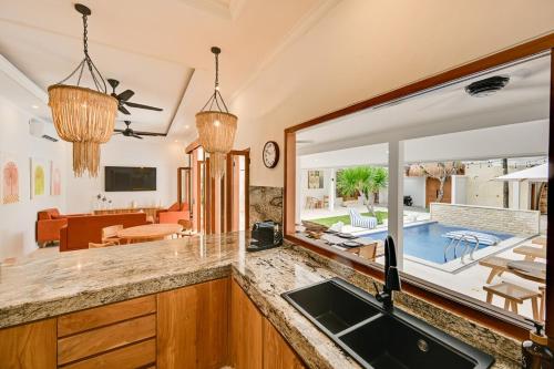 a kitchen with a sink and a view of a living room at Villa Mawali in Legian