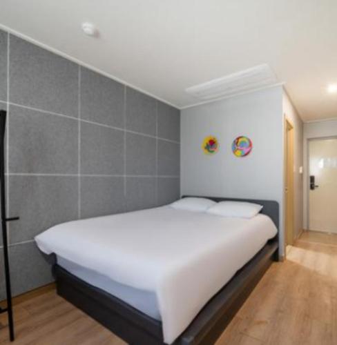 a bedroom with a large white bed in a room at Stay Hyun in Jeju