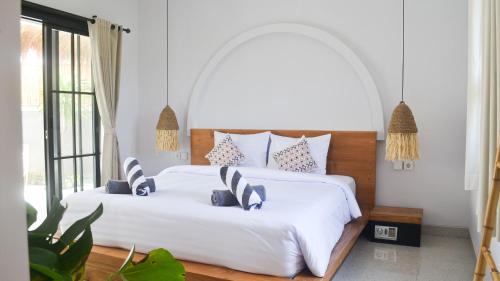 two beds in a bedroom with white walls at Pandan Villas, Canggu in Dalung