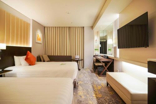 a hotel room with two beds and a couch at Solaria Nishitetsu Hotel Seoul Myeongdong - Renovated in 2025 in Seoul