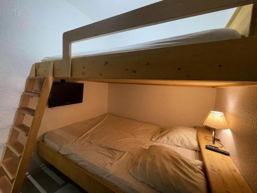 - une chambre avec des lits superposés, un bureau et une lampe dans l'établissement Résidence Sappey - Bel appartement avec balcon MAE-5521, à Vénosc