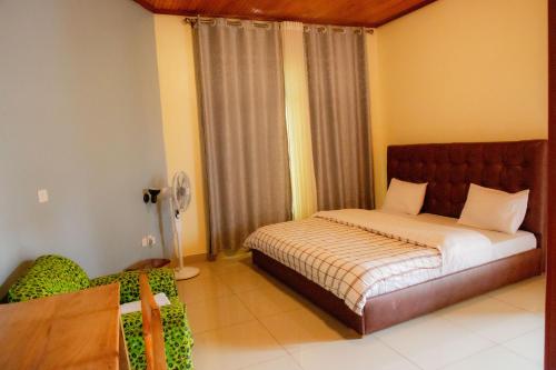 a bedroom with a bed and a chair in it at The Vista Homes Kibagabaga in Kigali