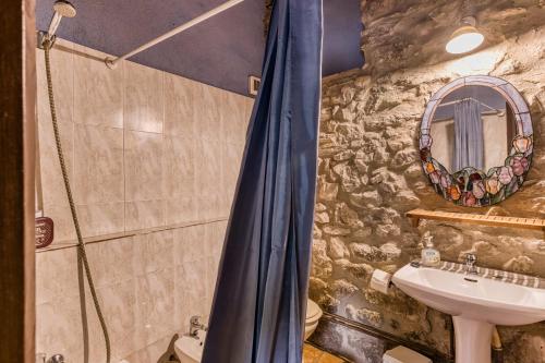 a stone bathroom with a shower and a sink at Can Pei in Oix