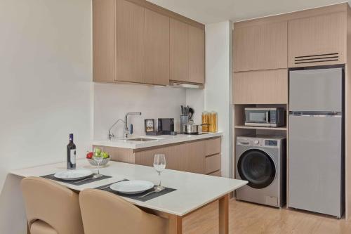 a kitchen with a table and chairs and a refrigerator at Lanson Place Mall of Asia Manila in Manila