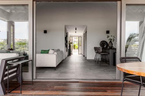 a living room with a couch and a table at Villa Jazmyn 15 Blue Bay Beach with Private pool in Sint Michiel