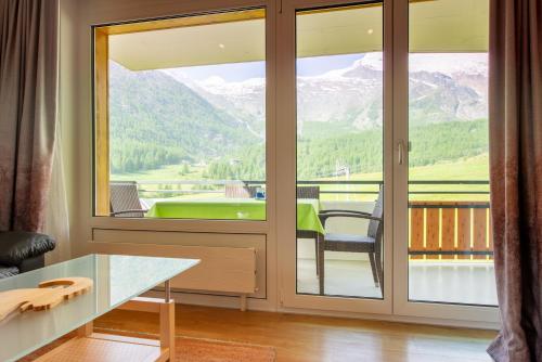 a room with a glass door with a view of the mountains at Dolce Vita in Saas-Fee