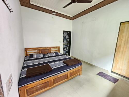 a bedroom with a wooden bed in a room at Daksh Holiday Home in Alibaug