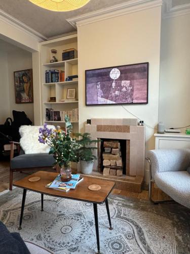 a living room with a table and a fireplace at Station House in Moffat