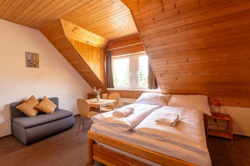 a bedroom with a large bed in a wooden ceiling at Aberto Jizerky in Albrechtice v Jizerských horách
