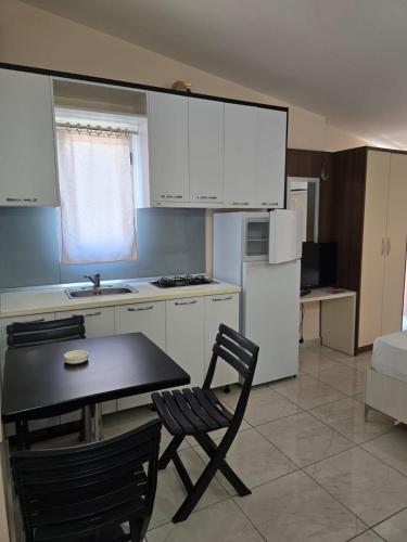 a kitchen with a table and a chair and a refrigerator at TRiAD in Vlorë