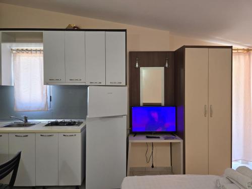 a kitchen with a refrigerator and a tv on a table at TRiAD in Vlorë