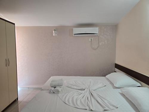 a bedroom with a white bed with a fan at TRiAD in Vlorë