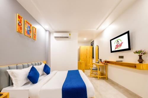a bedroom with a bed and a desk at Hotel Zest Near IGI Airport in New Delhi