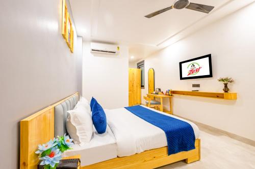a bedroom with a bed with blue and white pillows at Hotel Zest Near IGI Airport in New Delhi