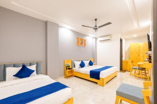 a bedroom with two beds and a table at Hotel Zest Near IGI Airport in New Delhi