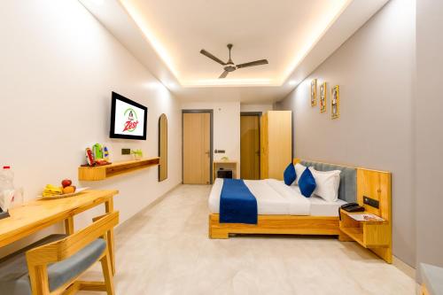 a bedroom with a bed and a desk in it at Hotel Zest Near IGI Airport in New Delhi