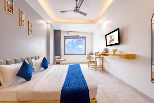 a bedroom with a large bed with blue pillows at Hotel Zest Near IGI Airport in New Delhi